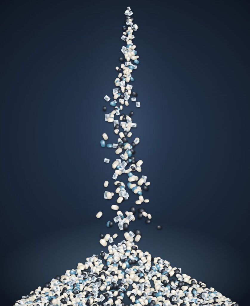 Natural, clear, black and blue resin pellets pouring into a pile
